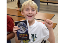 A Glenwood third-grader proudly holds his new dictionary.
