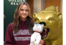 Grace Haven, Vestal High School field hockey team member, holds a stuffed toy husky dog as she stands next to the Golden Bear statue wearing a maroon Bloomsburg University hoodie before her athletic signing ceremony on January 12, 2023.