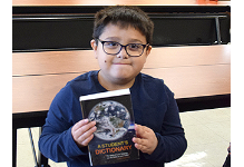 A Tioga Hills Elementary School third-grader holds his new dictionary, a gift from the Vestal Elks.