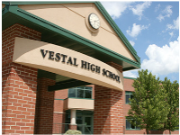 Exterior of the Vestal High School clock tower with a blue sky and white clouds behind it.