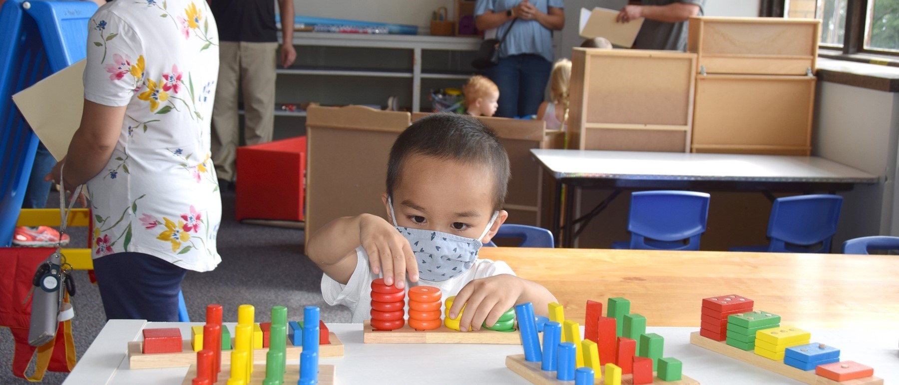 A boy who will be attending the Universal Pre-Kindergarten program at the Cub Care Childrens Center campus plays with colored rings during Orientation.