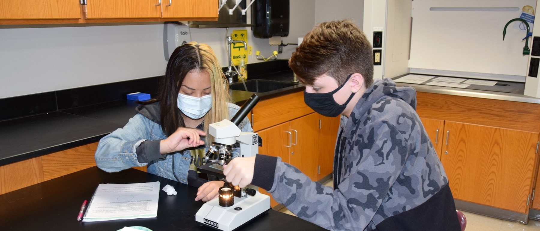Two Vestal High School students learn how to prepare a slide and use a microscope in their Living Environment classroom.