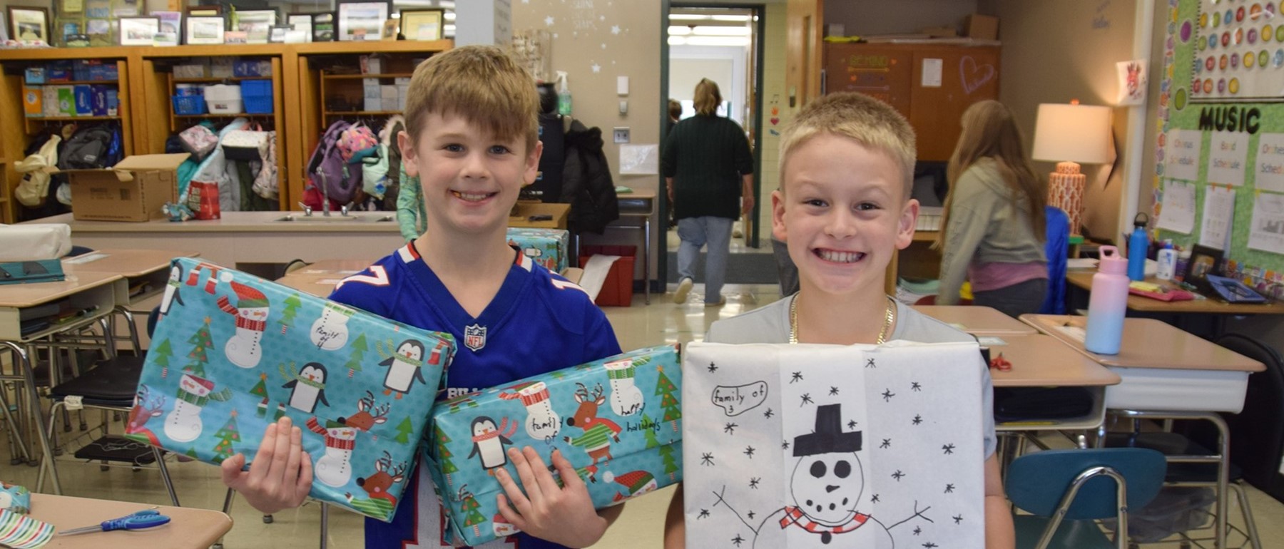 Two Tioga Hills Elementary fifth-grade boys hold the shoes boxes they filled with personal care items and wrapped for patrons of the Apalachin Food Pantry.