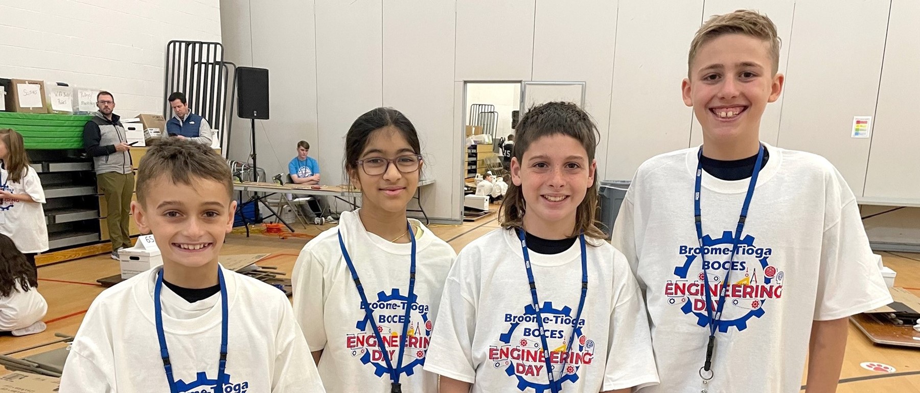 Four Glenwood fifth-graders in Engineering Day shirts smile at the camera as the prepare to compete on November 16, 2023.