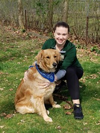 Glenwood Elementary School Nurse Heather Kirchheimer with a Golden Retriever dog.